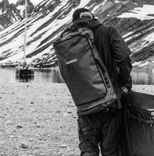 Load image into Gallery viewer, Person wearing the Manera Rugged Waterproof Duffelbag Backpack 45L
