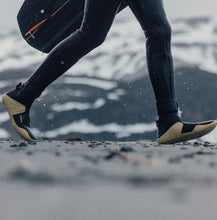 Load image into Gallery viewer, Surfer walking on the beach wearing Manera Magma Booties
