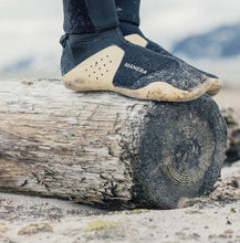 Load image into Gallery viewer, Close up of surfing booties being worn by a person standing on a log
