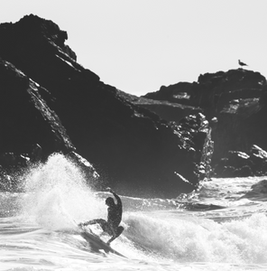 Woman surfer doing a sick layback snap in a Manera Wetsuit.